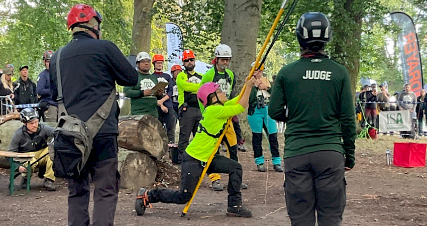 Hilla Kyrö ampumassa ritsalla heittonarua puuhun, jonka avulla kiipeilyköysi asetetaan paikalleen. Kuva: Tapani Mäkelä